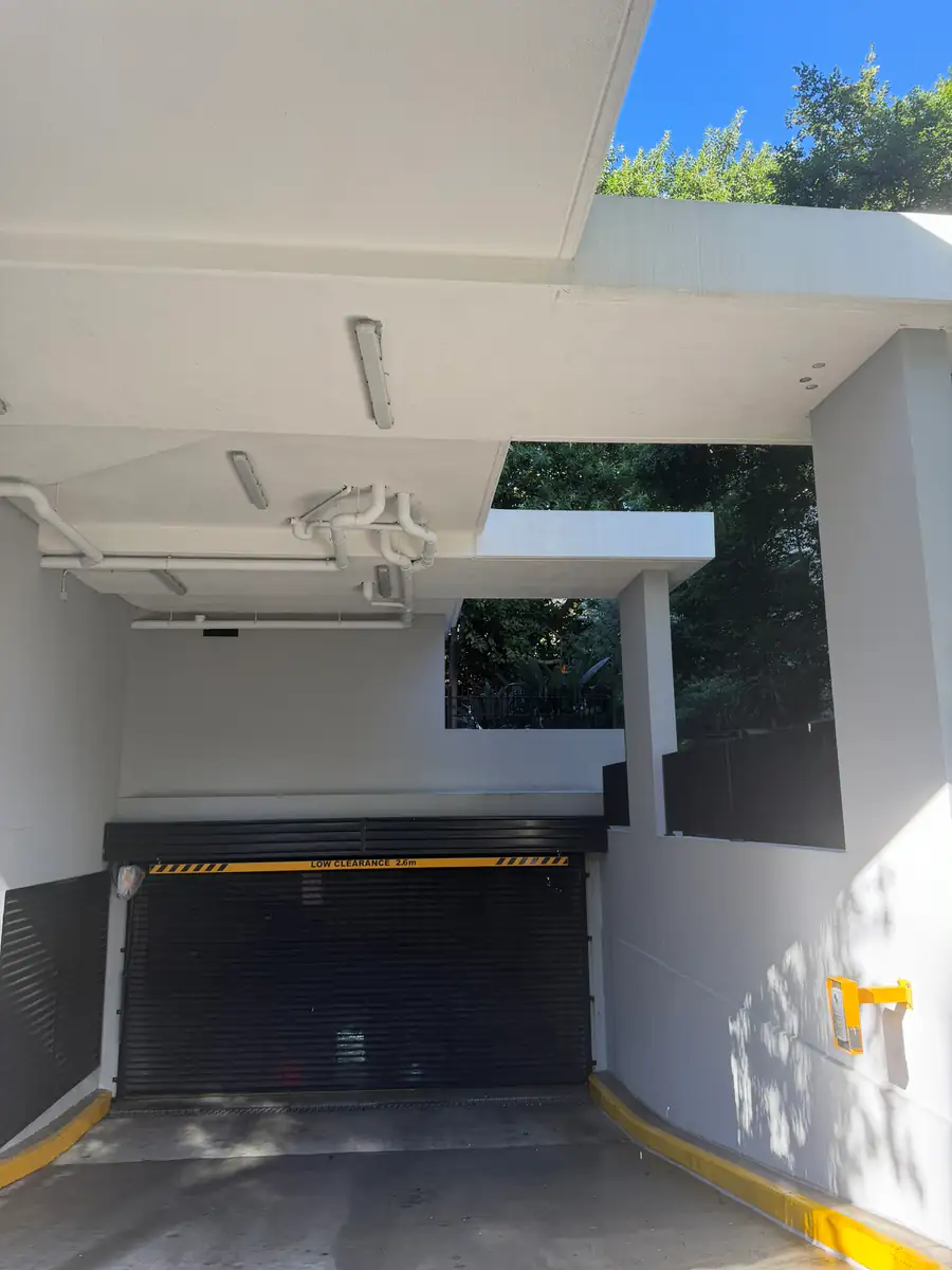 The car park entry after soft washing, with white render and a clean soffit